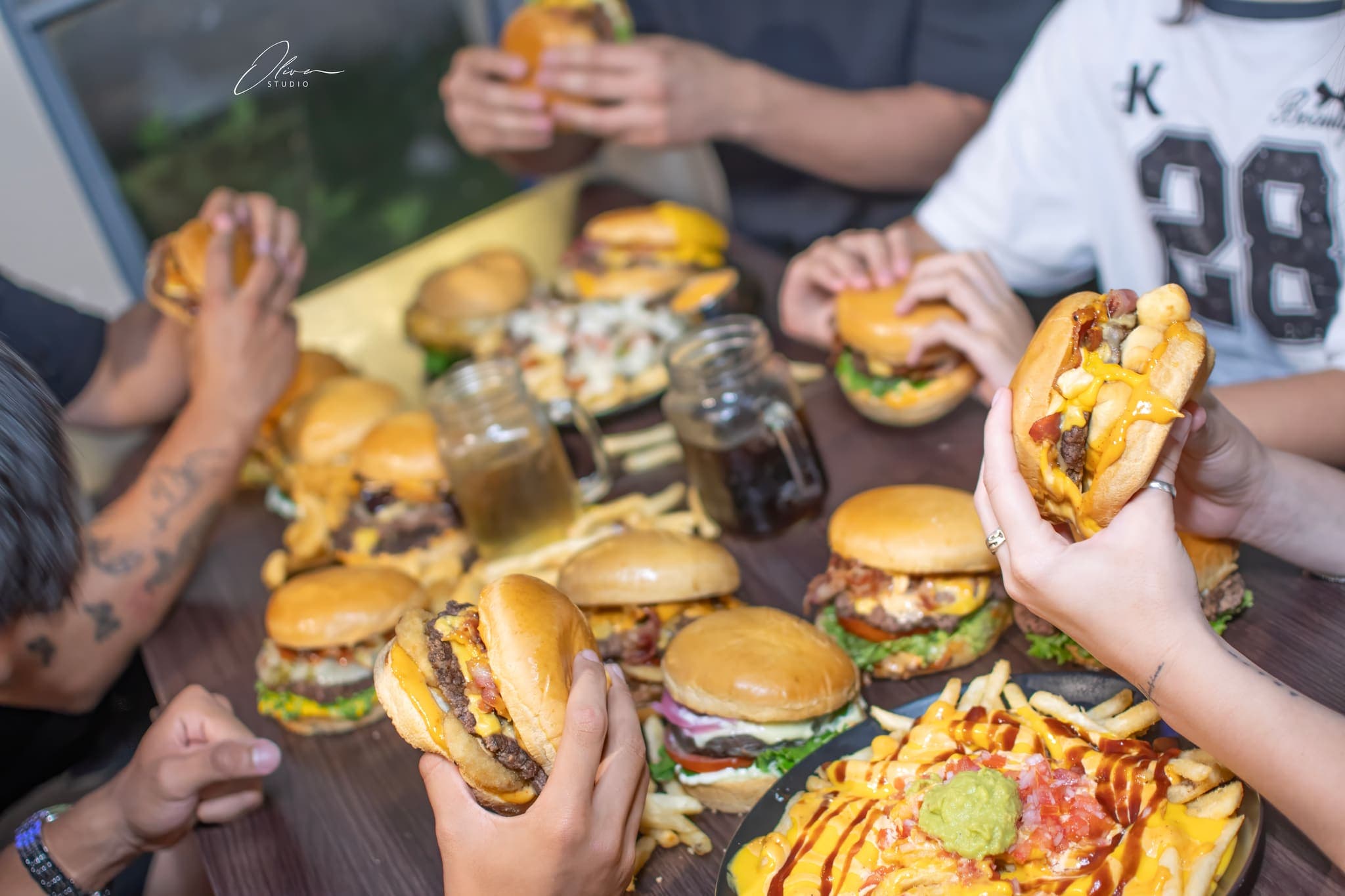 Mesa compartida con hamburguesas y papas para una marca de comida